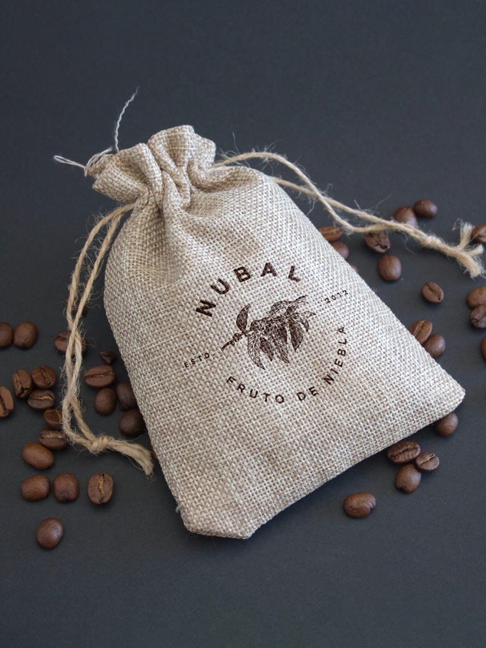 Costalito de tela con el sello de Nubal y granos de café