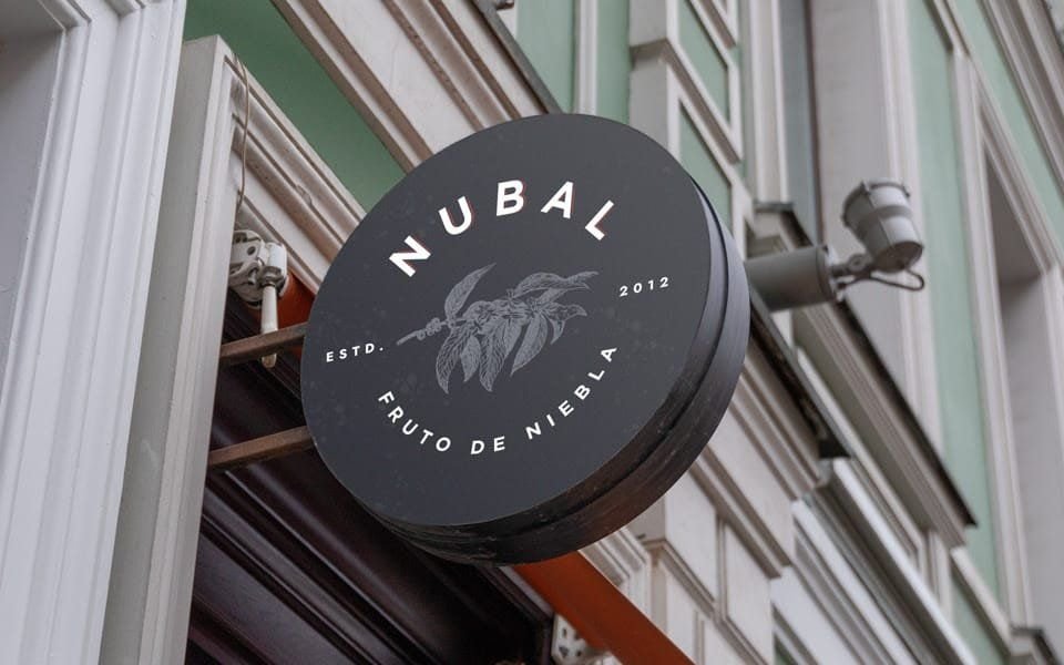 Letrero circular de Nubal en la fachada de la cafetería